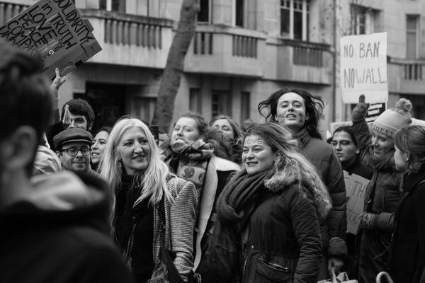 Kvinnor med plakat marcherar på Paris gator.