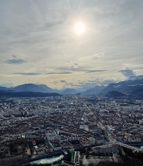 Grenoble uppifrån med berg och sol i bakgrunden