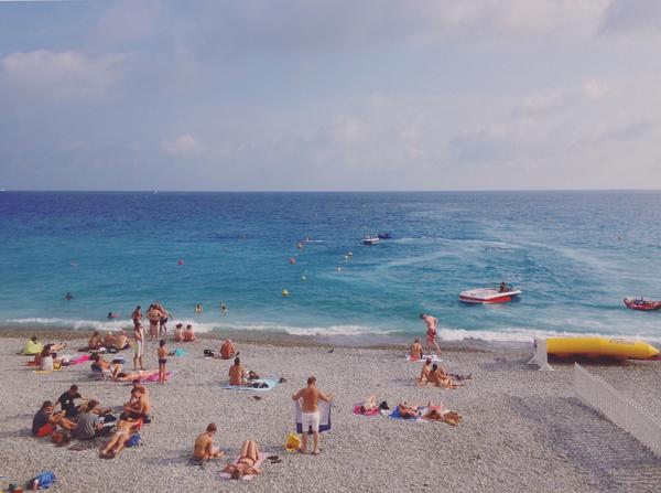 Strandbesökare njuter av solen och Medelhavet i Nice.